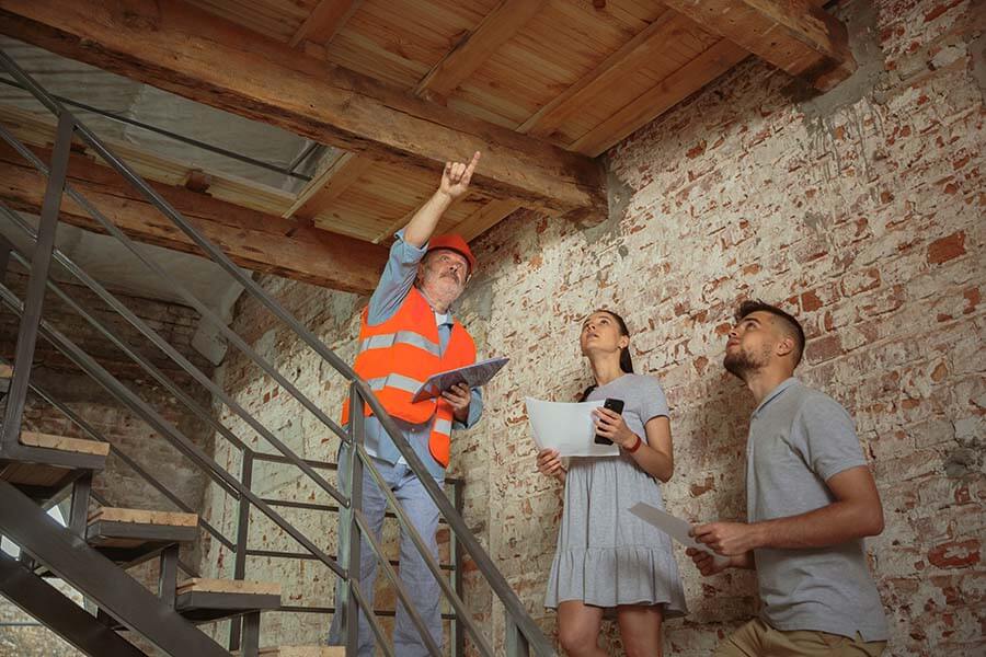 A client and engineer inspect the interior of a home financed with a construction loan.